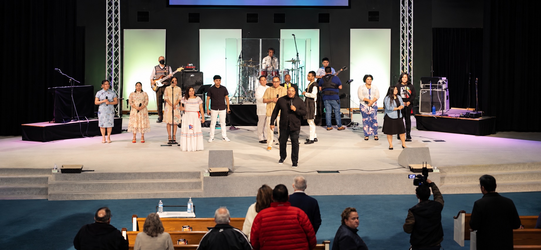 Worship leaders on stage with a congregation in the foreground